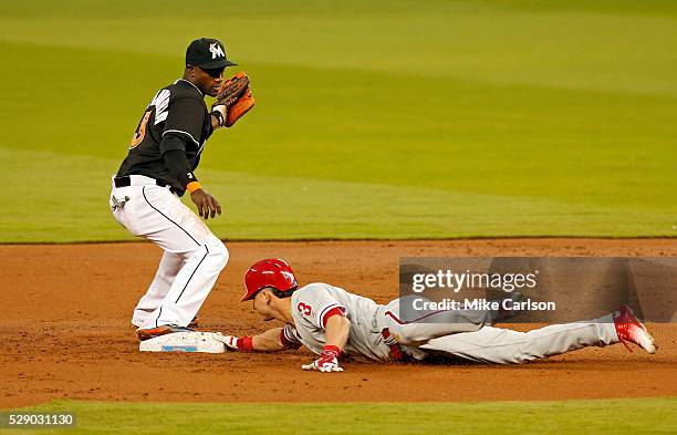 David Lough of the Philadelphia Phillies slides in safely with a double ahead of a tag from Adeiny Hechavarria of the Miami Marlins during the third...