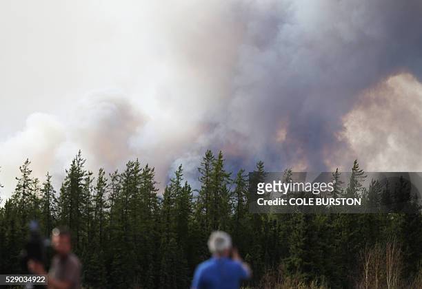 Smoke rises off Highway 63 on May 7, 2016 outside Fort McMurray, where raging forest fires have forced more than 88,000 from their homes. A ferocious...