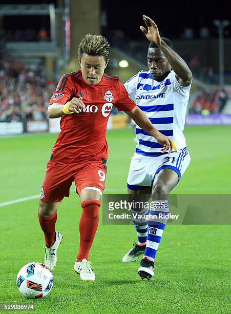Tsubasa Endoh of Toronto FC battles for the ball with Maynor Figueroa of FC Dallas during the second half of an MLS soccer game at BMO Field on May...