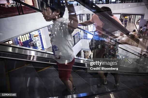 People ride an escalator at Ayala Land Inc.'s Greenbelt shopping mall in Makati City in Manila, the Philippines, on Friday, May 6, 2016. Stocks fell,...