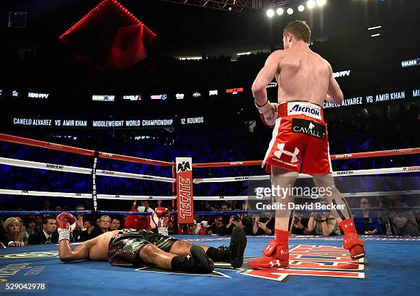 Canelo Alvarez stands over Amir Khan after delivering a knockout during the sixth round of their WBC middleweight title fight at T-Mobile Arena on...