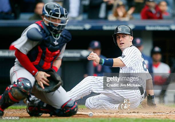 Dustin Ackley of the New York Yankees scores a run in the fourth inning ahead outfield the throw to Christian Vazquez of the Boston Red Sox at Yankee...