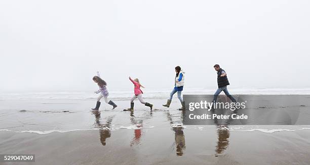 family on beach balancing on stepping stones . - wasser treten stock-fotos und bilder