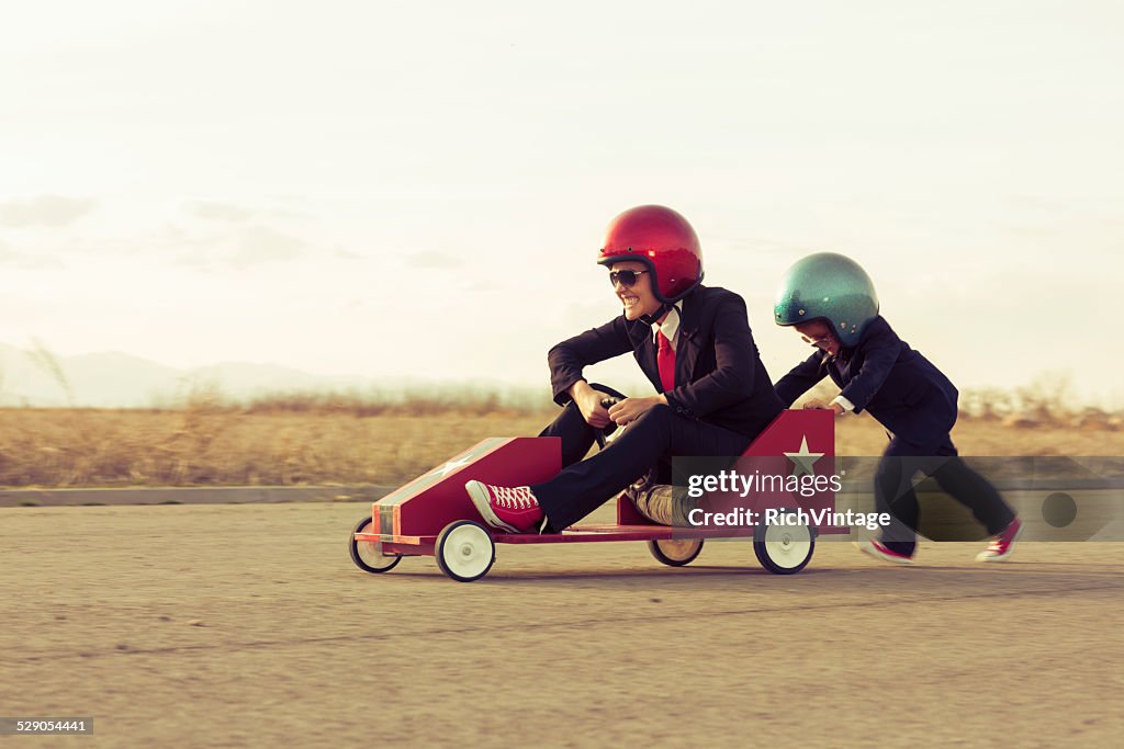 Young Boy with Businesswoman Racing a Toy Car