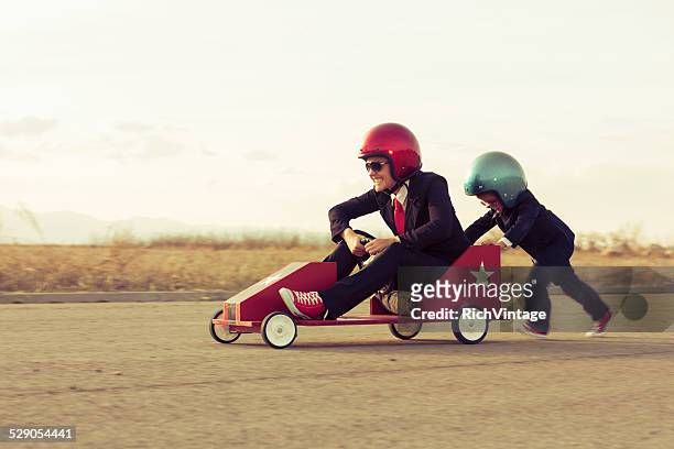 young boy with businesswoman racing a toy car - business man driving bildbanksfoton och bilder