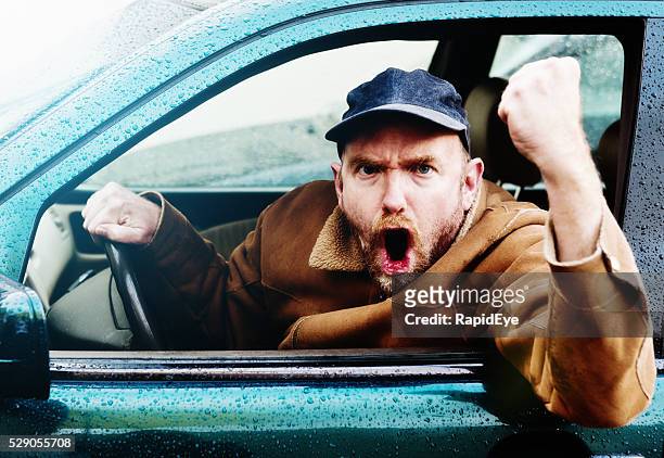 road rage: furious male driver yelling, shaking fist through window - raid stockfoto's en -beelden