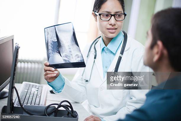 female orthopedics doctor holding x-ray image and talking to patient. - human vertebra 個照片及圖片檔