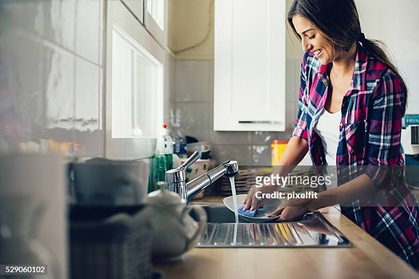 young woman dish washing - dirty dishes stockfoto's en -beelden
