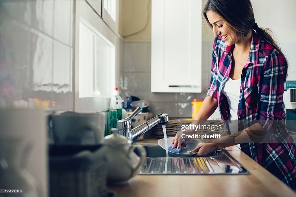 Young woman dish washing