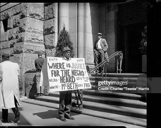 Vincent 'Roots' Wilson protesting in front of Allegheny County Courthouse with placard reading 'Where is justice for the Negro - Heard gets 9 to 18...