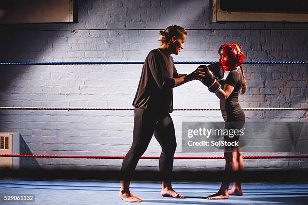 teaching her to fight! - kids boxing stockfoto's en -beelden