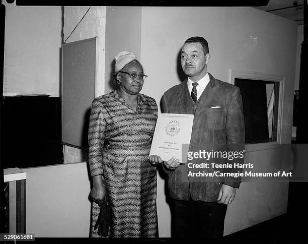 Man and woman holding document inscribed 'NAACP Founded 1909 Over 50 Years, Campaign Kit For Membership Chairmen,' in interior, Pittsburgh,...
