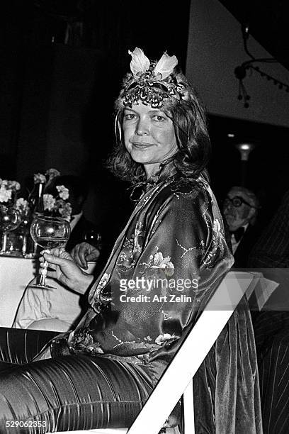 Ellen Burstyn at a costume party, seated at a table; circa 1960; New York.