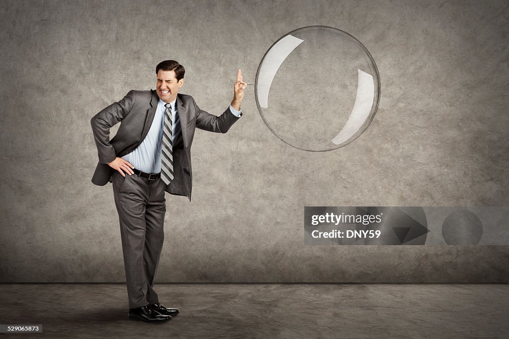 Businessman Popping A Bubble