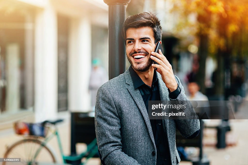 Casual hombre de negocios con teléfono al aire libre