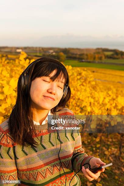 young woman enjoy music in vineyard switzerland - xenotar stockfoto's en -beelden