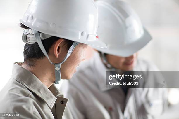 architect and engineer at a building site - construction meeting helmet stock pictures, royalty-free photos & images