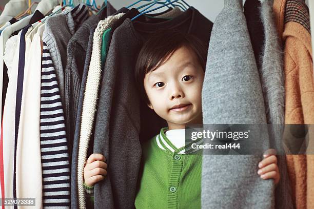 enfant jouant dans le placard - cintre photos et images de collection