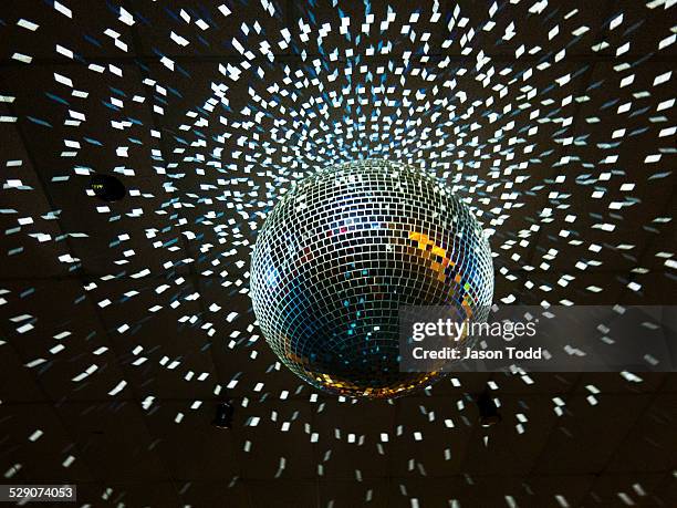 disco ball with lights hanging from ceiling - using a swing stockfoto's en -beelden