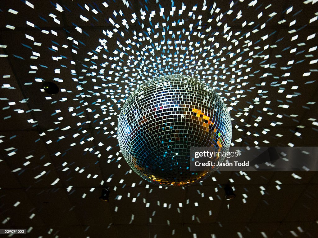 Disco ball with lights hanging from ceiling