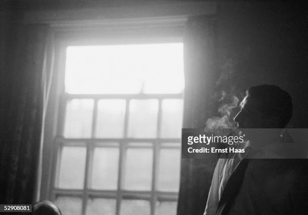Hungarian-born American photojournalist Robert Capa , during a visit to film director John Huston in hospital, 1953.