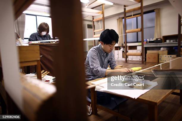 Drawing master Ryugo Yamamoto mixes paint to apply to a design on kimono fabric during a stage of its production process at the Sensyo Ichikawa...