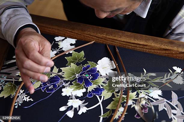 Stitching master Hitoshi Nakano works on a kimono during a stage of its production process at the Sensyo Ichikawa kimono workshop on April 26, 2016...