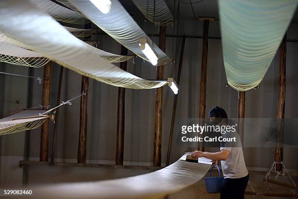Fabric dye master applies dye to kimono fabric during a stage of its production process at the Sensyo Ichikawa kimono workshop on April 26, 2016 in...