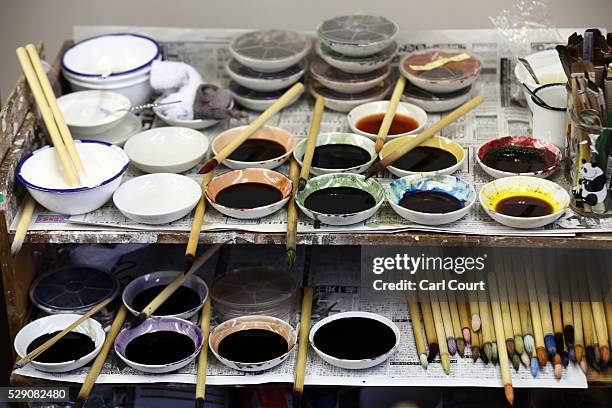 Dyes and brushes for colouring patterns on kimono fabric are placed on a shelf at the Sensyo Ichikawa kimono workshop on April 26, 2016 in Kyoto,...