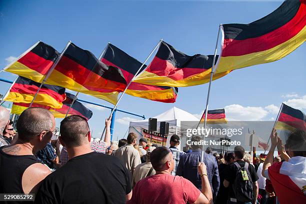 Right-wing activists hold banners and scream slogans during a demonstration to protest under the motto 'Merkel must go' against German Chancellor...