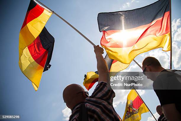 Right-wing activists hold German flags and scream slogans during a demonstration to protest under the motto 'Merkel must go' against German...