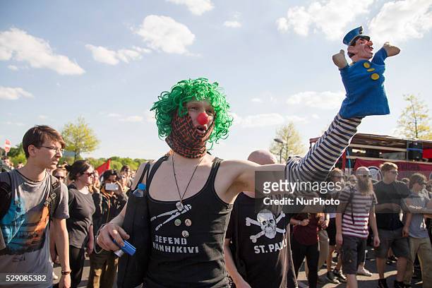 Masked protester holds a policeman puppet during a protest against right-wing activists marching in the city center in Berlin, Germany on May 7,...