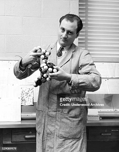 Behavioral geneticist and molecular biologist Dr Seymour Benzer of Purdue University holding a model of molecules, West Lafayette, Indiana, 1961.