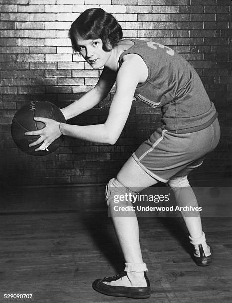 Portrait of Kathy Miller, captain and guard for the Tri-Chi-Girls basketball team and AAU champions for the past two years, Chicago, Illinois, circa...