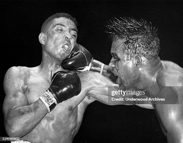 Sugar Ray Robinson throws a hard right to the jaw of middleweight champion Randy Turpin in the tenth round of their title bout at the Polo Grounds,...