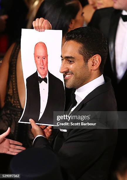 Waleed Aly holds a photo of Ray Meagher from Home and Away aloft as he arrives at the 58th Annual Logie Awards at Crown Palladium on May 8, 2016 in...