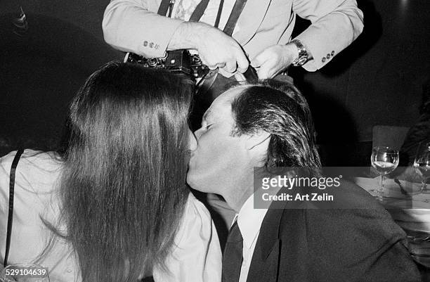 Jack Nicholson kissing Anjelica Huston at a formal dinner; circa 1970; New York.