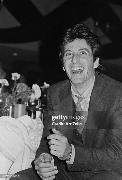 Al Pacino seated at a dinner table, laughing; circa 1970; New York.