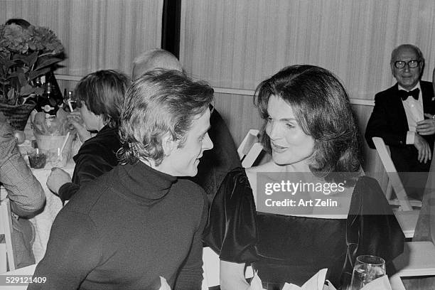 Jacqueline Kennedy Onassis and Mikhail Baryshnikov seated at a table in conversation. Mrs. Onassis is wearing velvet; circa 1970; New York.