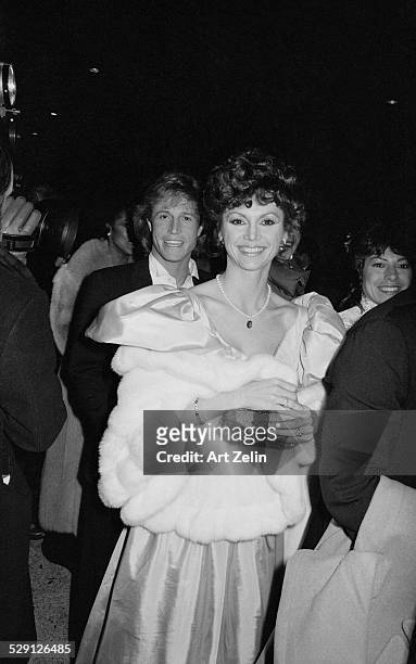 Andy Gibb and Victoria Principal entering event; circa 1970; New York.