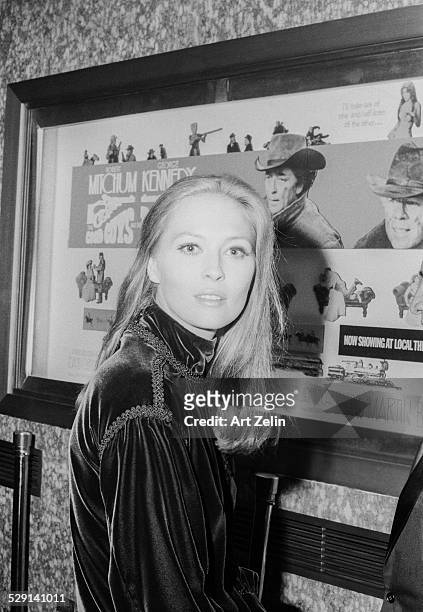 Faye Dunaway in front of a movie poster for "The Good Guys and The Bad Guys, at the theater, 1969; circa 1970; New York.