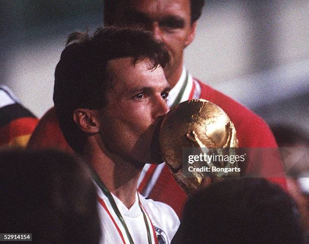 Mailand, 08.07.90, DEUTSCHLAND FUSSBALLWELTMEISTER 1990/DEUTSCHLAND WELTMEISTER 1990, Lothar MATTHAEUS kuesst den WM Pokal/Cup