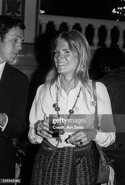 Candice Bergen, holding a drink, talking with a friend; circa 1970; New York.