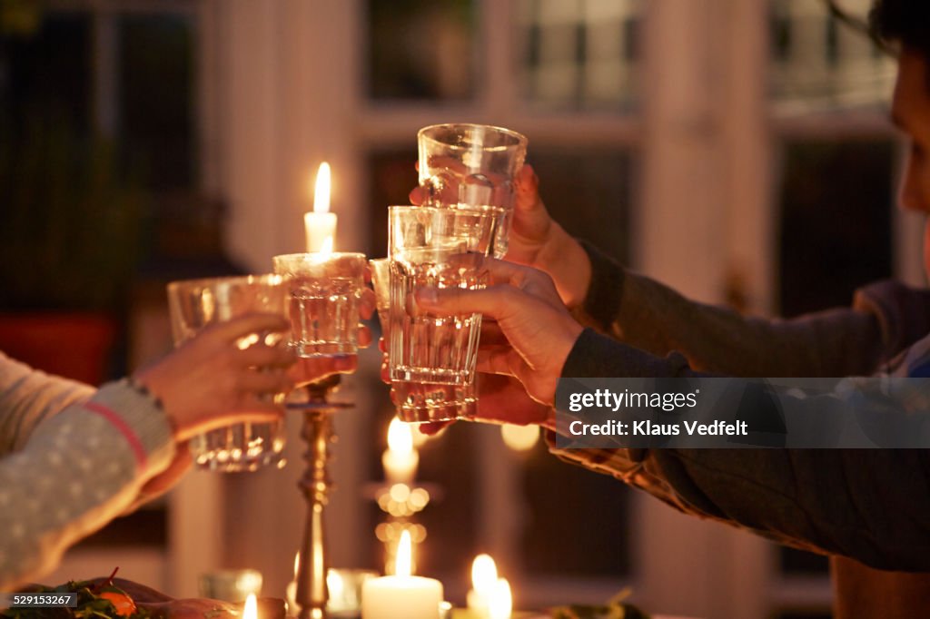 Family toasting at dinner with candle lights