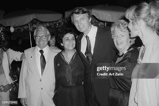 Alan Alda with his wife Arlene, with dark hair, and friends at an outdoor event; circa 1970; New York.