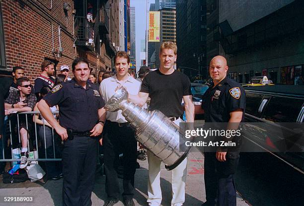 The New Jersey Devil's Hockey Team with the Stanley Cup, 1995. MVP Claude Lemieux left of the man holding the cup. They are being interviewed on the...