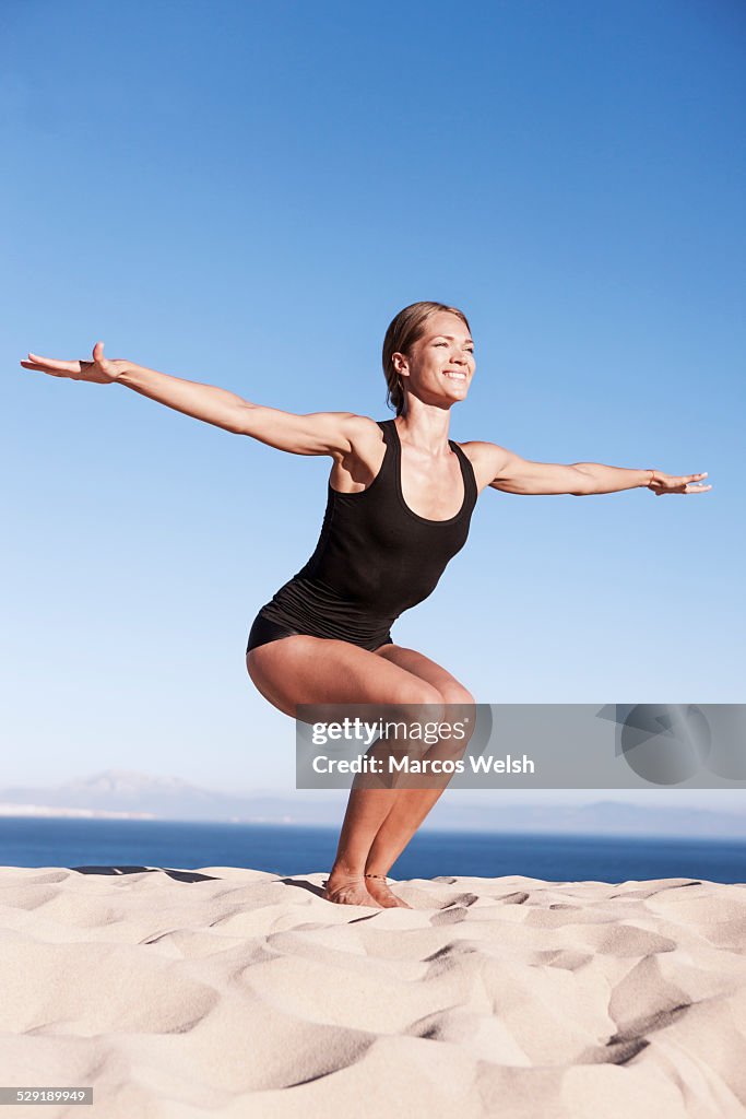 Young woman exercising on beach