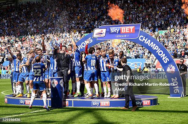 Stephen Warnock of Wigan Athletic sprays champagne on his team-mates as Wigan celebrate winning the 2015/16 Sky Bet League One Championship at the...