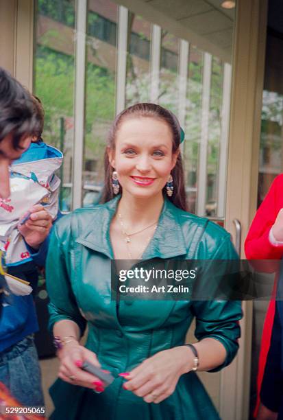 Valerie Harper, wearing green leather, signing autographs ; circa 1990; New York.