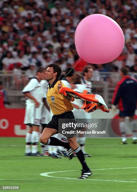 Lyon, 21.06.98, USA 2 , Schiedsrichter Urs MEIER/SUI entfernt einen Luftballon mit Spruchband.